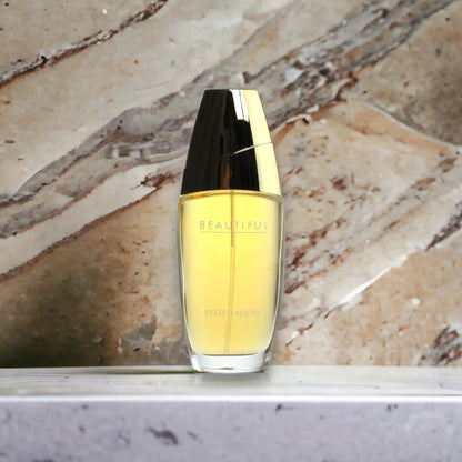 Eleganter Damenparfum-Flakon mit goldener Kappe vor Marmorhintergrund, Eau de Parfum