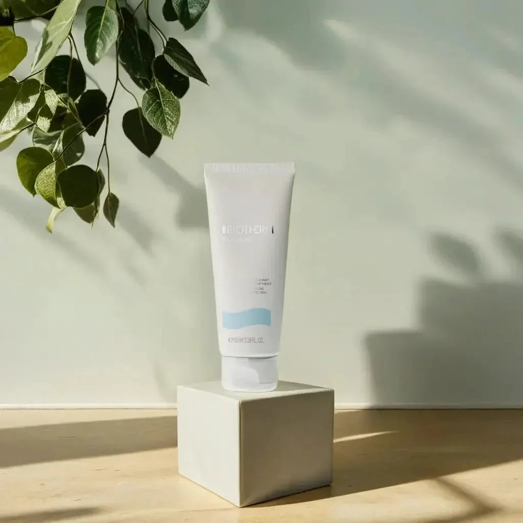 Handcreme-Tube auf Würfelpodest, nah, mit Blatt-Schatten und natürlichem Licht