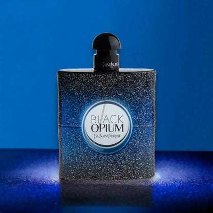 Schwarzer, glitzernder Parfumflakon Black Opium Intense vor blauem Hintergrund