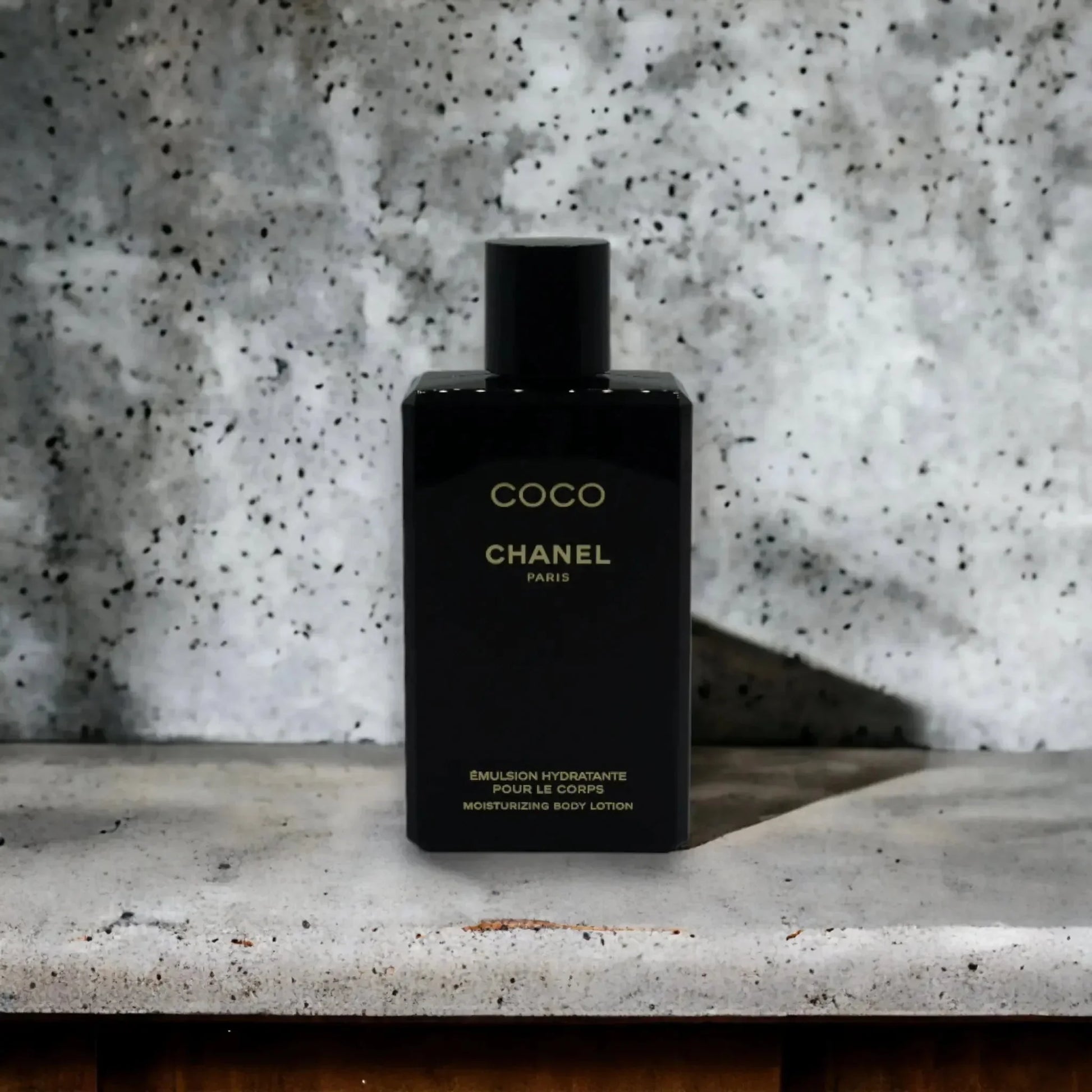 Schwarze Flasche Coco Chanel feuchtigkeitsspendende Bodylotion vor grauem Hintergrund