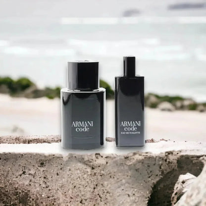 Armani Code Duftset mit zwei schwarzen Parfumflakons am Strand mit Meer im Hintergrund