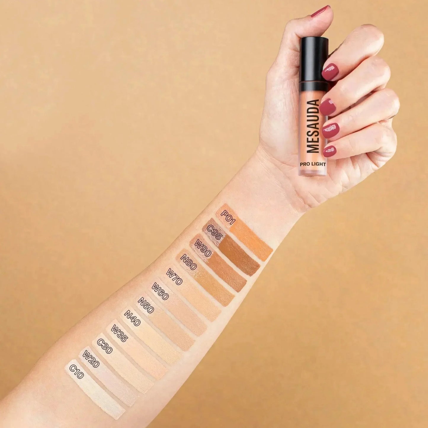 Hand mit Mesauda Pro Light Concealer und Farbnuancen auf dem Arm, verschiedene Concealer-Töne.
