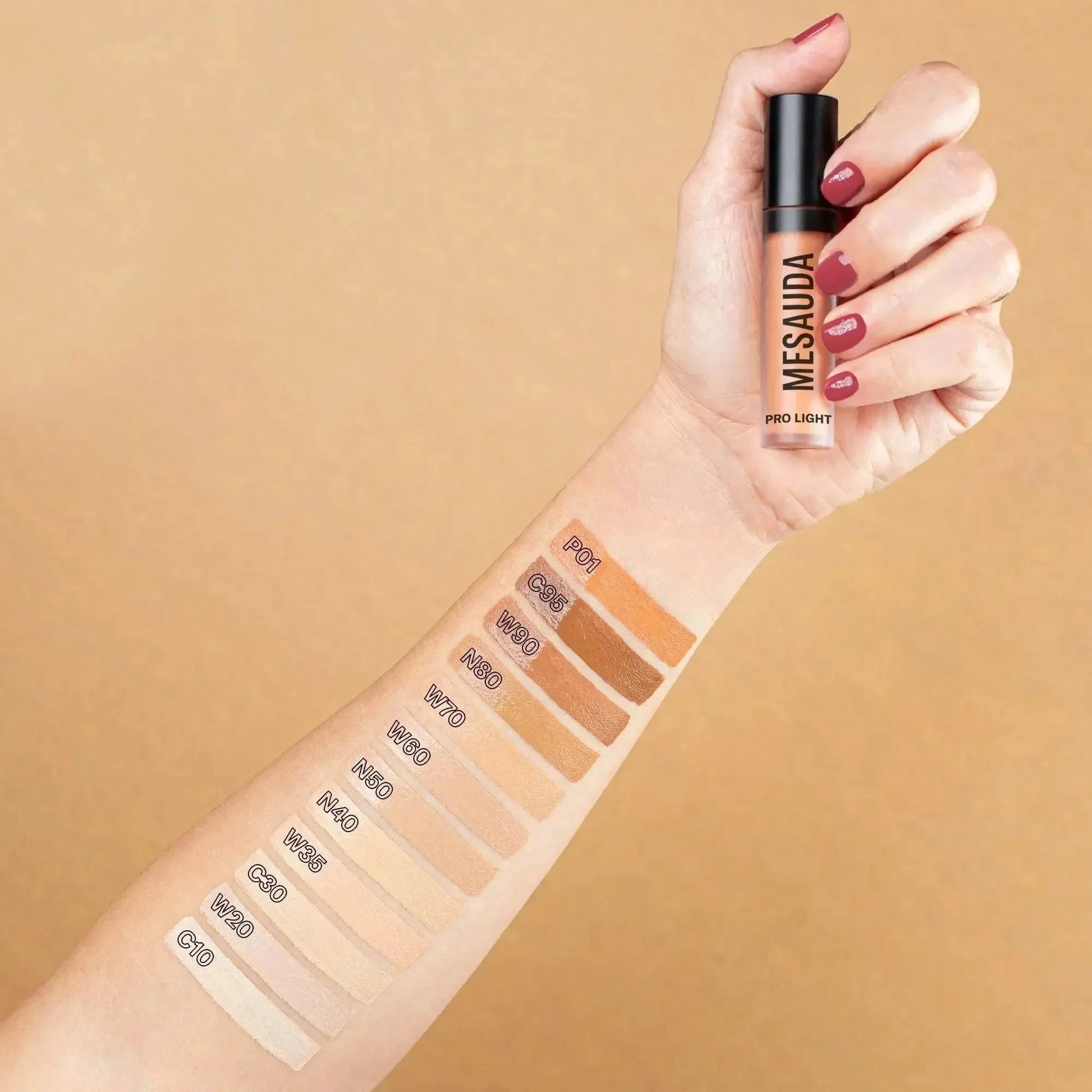 Hand mit Mesauda Pro Light Concealer und Farbnuancen auf dem Arm, verschiedene Concealer-Töne.