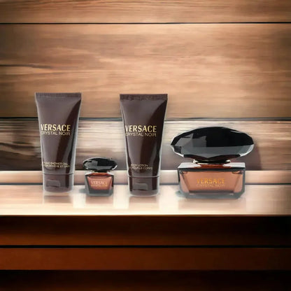 Versace Crystal Noir Duftset mit Eau de Toilette, Bodylotion und Duschgel vor Holzoptik