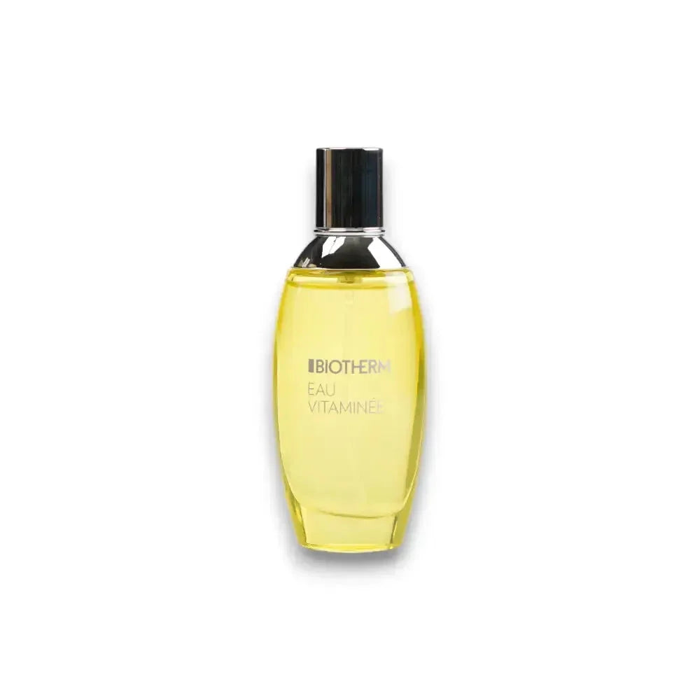Gelbes Eau de Toilette Biotherm Eau Vitaminée Flakon mit silbernem Deckel auf weißem Hintergrund