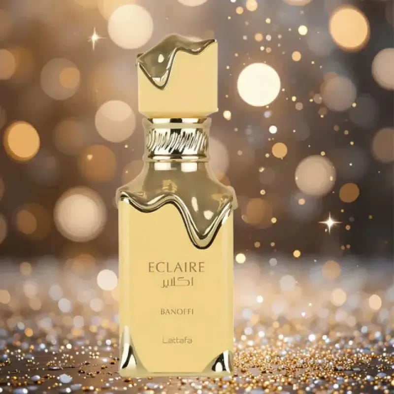 Luxus Parfumflakon Eclaire Banoffi goldfarben vor glitzerndem Hintergrund, Unisex Duft