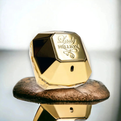 Goldener Lady Million Damenparfum Flakon auf Stein, luxuriöses Duftdesign