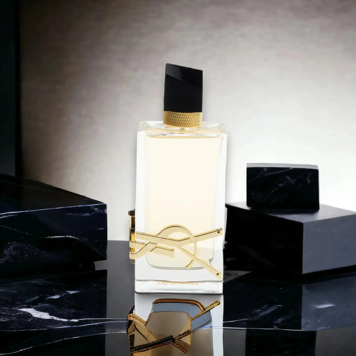 Luxusparfum-Flakon mit goldener Verzierung, schwarzem Deckel und elegantem Design auf Marmor