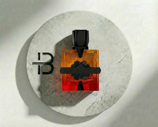 Luxusparfum-Flakon in Orange und Rot mit schwarzem Verschluss auf hellem Marmorteller