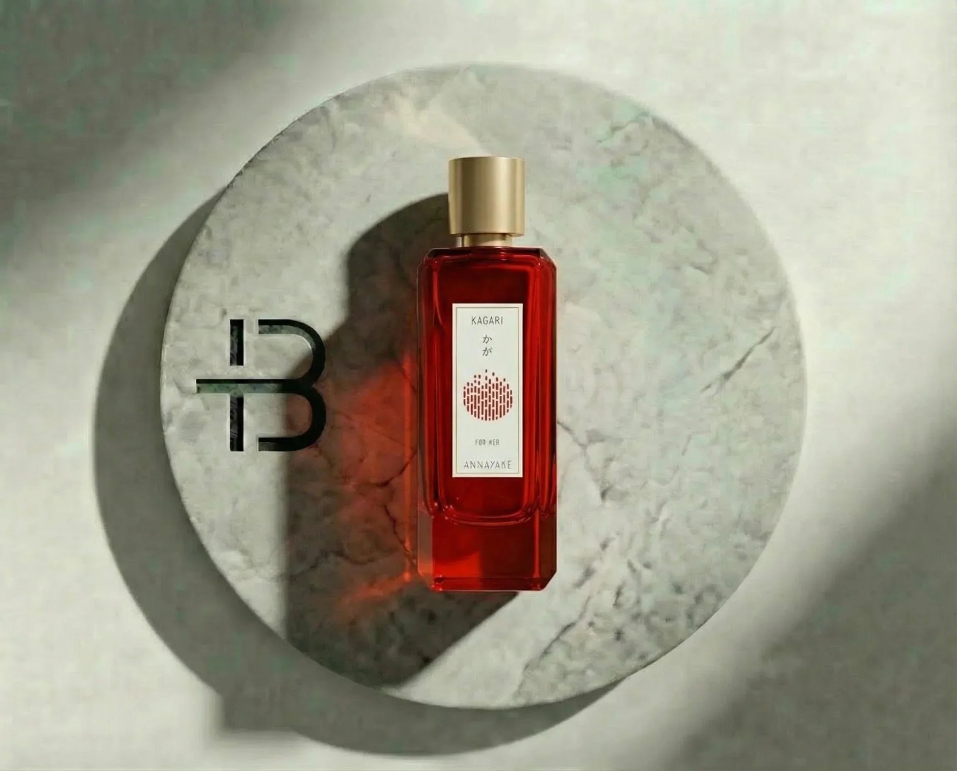Rotes Damenparfum Annayake KAGARI auf rundem Marmortablett, luxuriöses Duftdesign