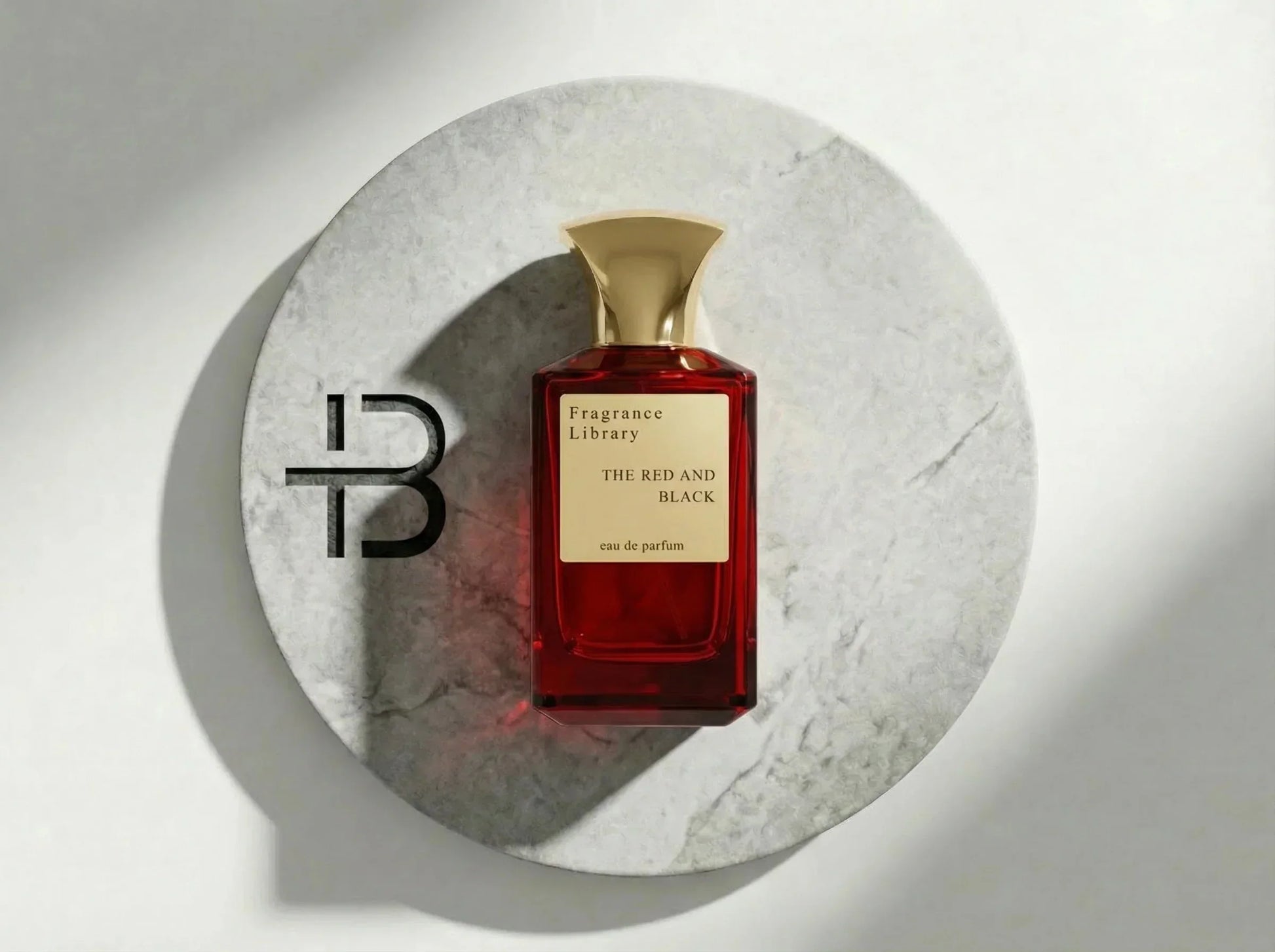Roter Parfumflakon mit goldener Kappe auf Marmorplatte, Luxusparfum, Duft für Damen und Herren