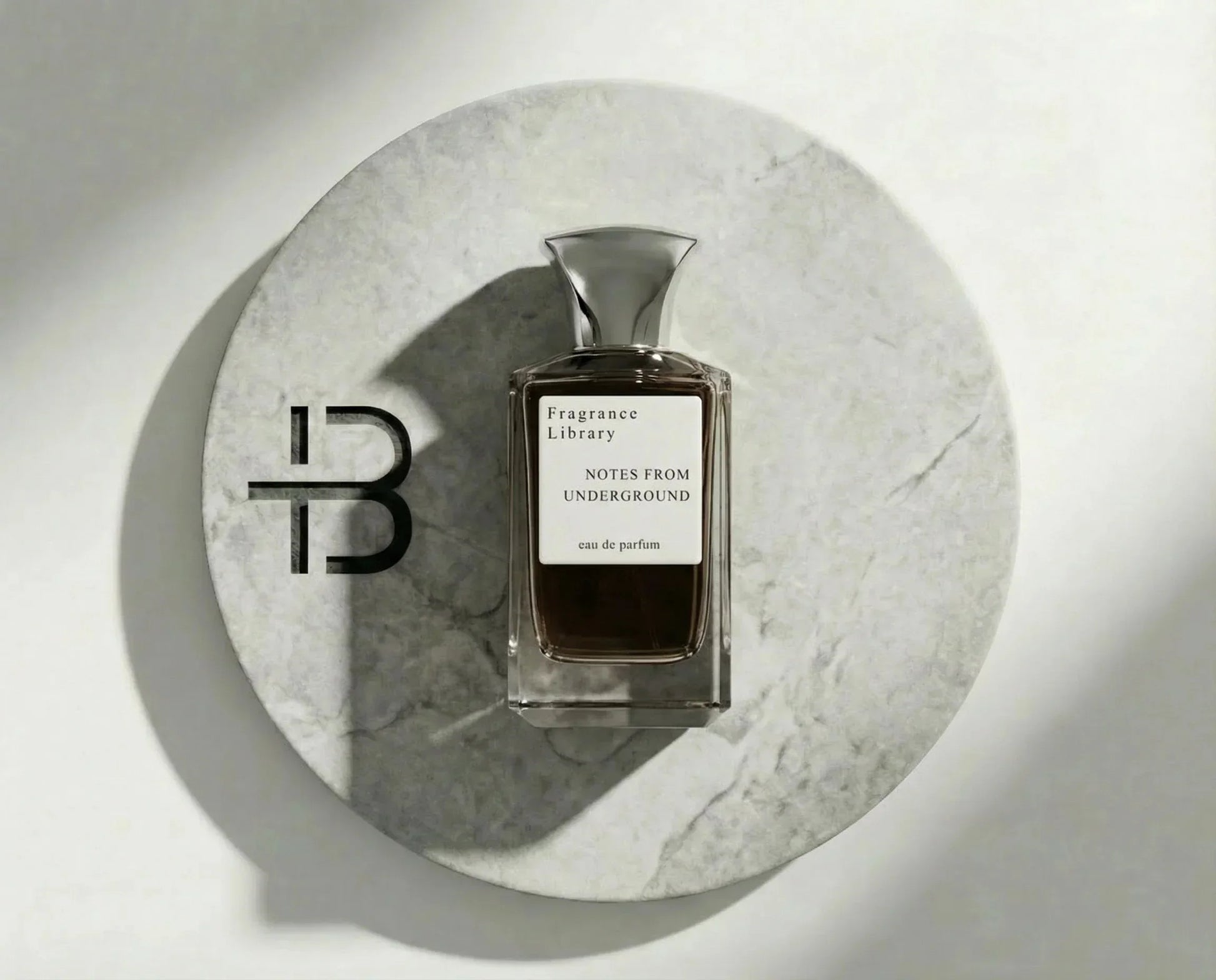 Luxusparfum-Flakon auf rundem Marmortablett, edles Eau de Parfum, minimalistische Präsentation