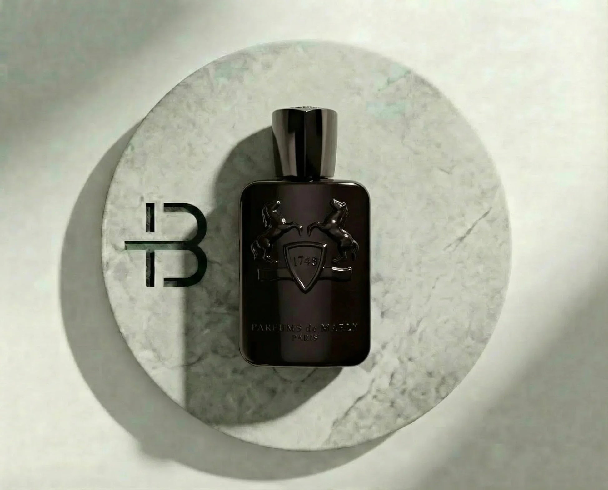 Schwarzer Luxusparfumflakon auf rundem Marmortablett, elegantes Design, Herrenduft