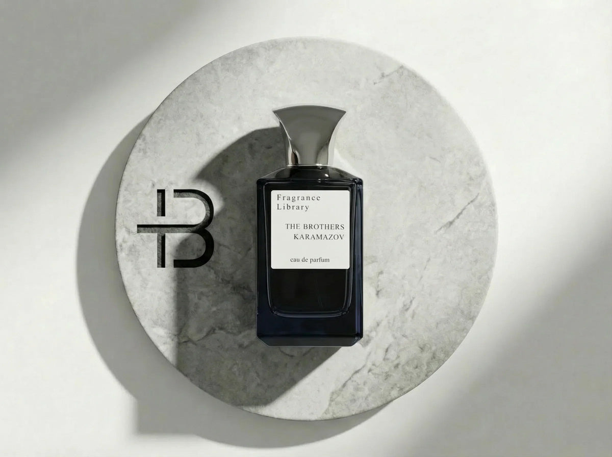 Fragrance Library The Brothers Karamazov Eau de Parfum Flakon auf weißem Marmorteller.