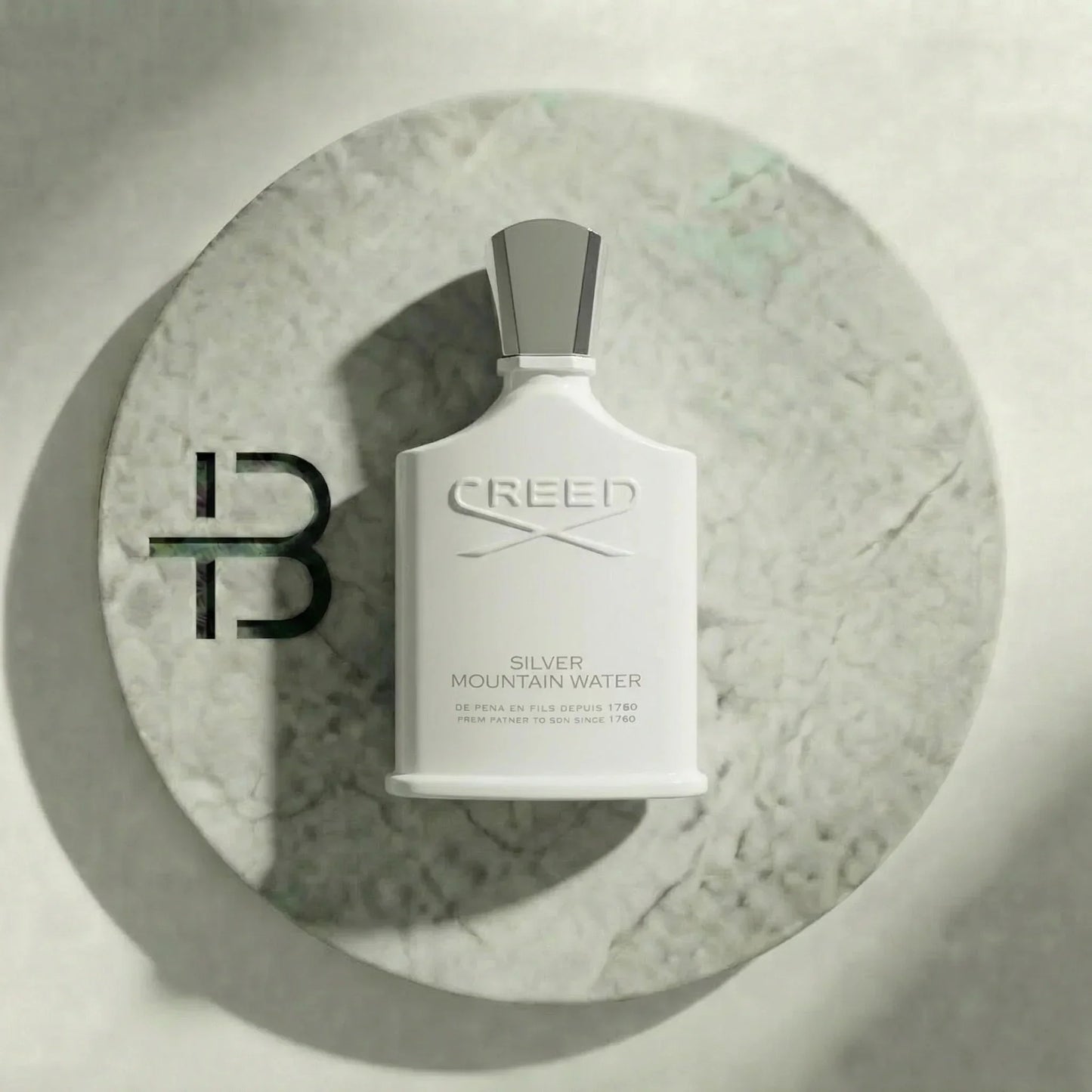Weißer Flakon Parfum Silver Mountain Water auf rundem Marmorsockel, luxuriöses Design