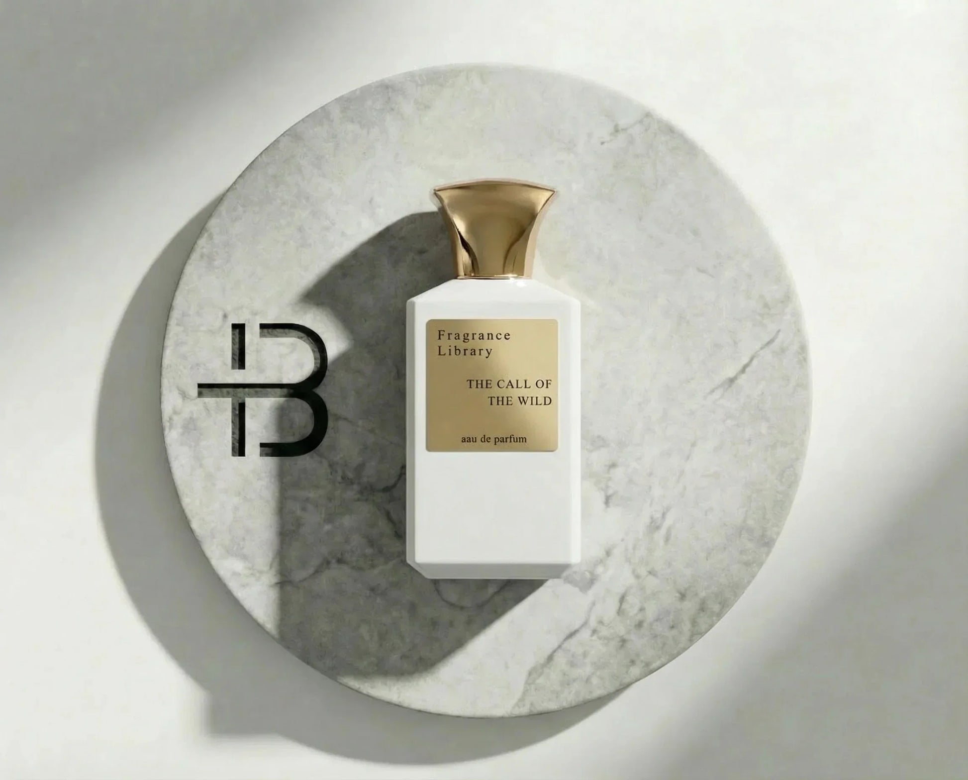 Luxuriöses Parfumflakon mit goldener Kappe auf Marmorscheibe, edle Duftpräsentation