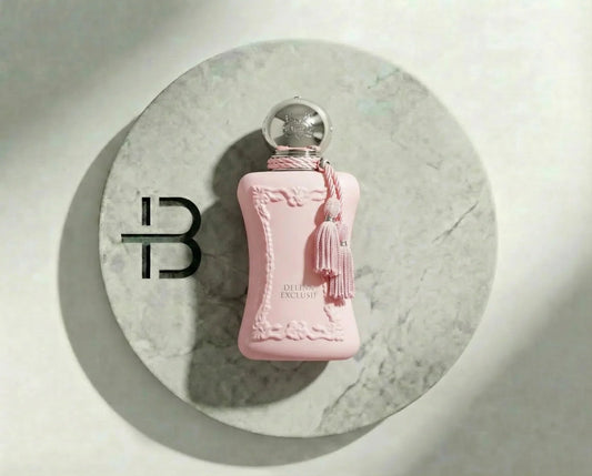 Luxus Damenparfum in rosa Flakon mit silbernem Verschluss und Quaste auf Marmorkreis