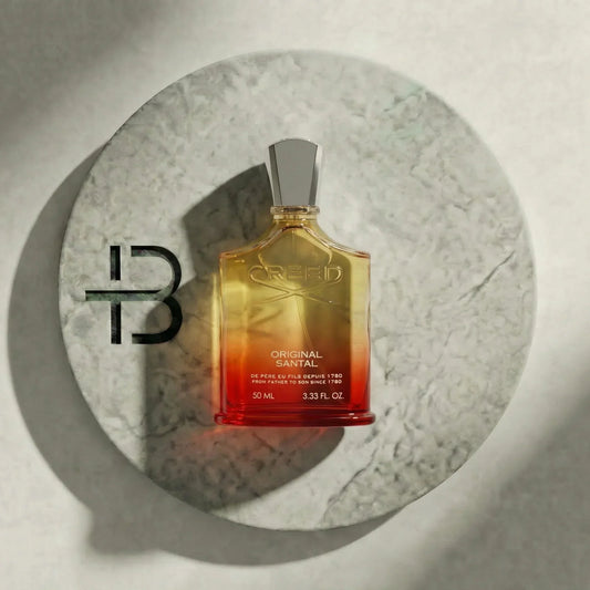 Luxusparfum Flakon Creed Original Santal mit silbernem Verschluss auf Marmorteller, edles Design