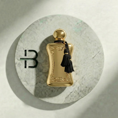 Goldenes Luxusparfum für Damen und Herren auf Marmorteller mit schwarzer Quaste.