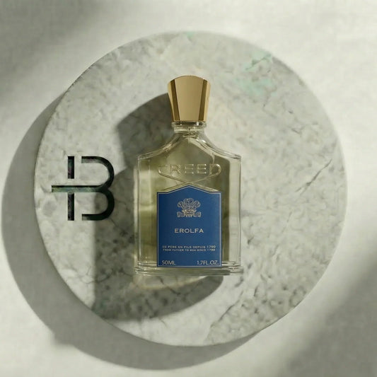 Luxusparfum-Flakon mit goldener Kappe und blauem Label auf marmoriertem Untergrund