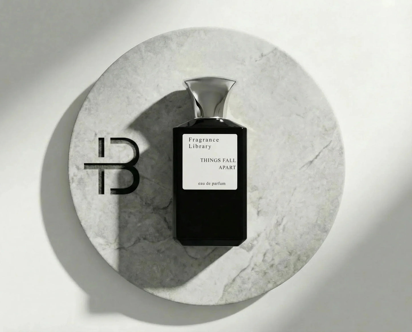 Edles Parfumflakon "Things Fall Apart" auf rundem Marmortablett, luxuriöser Duft