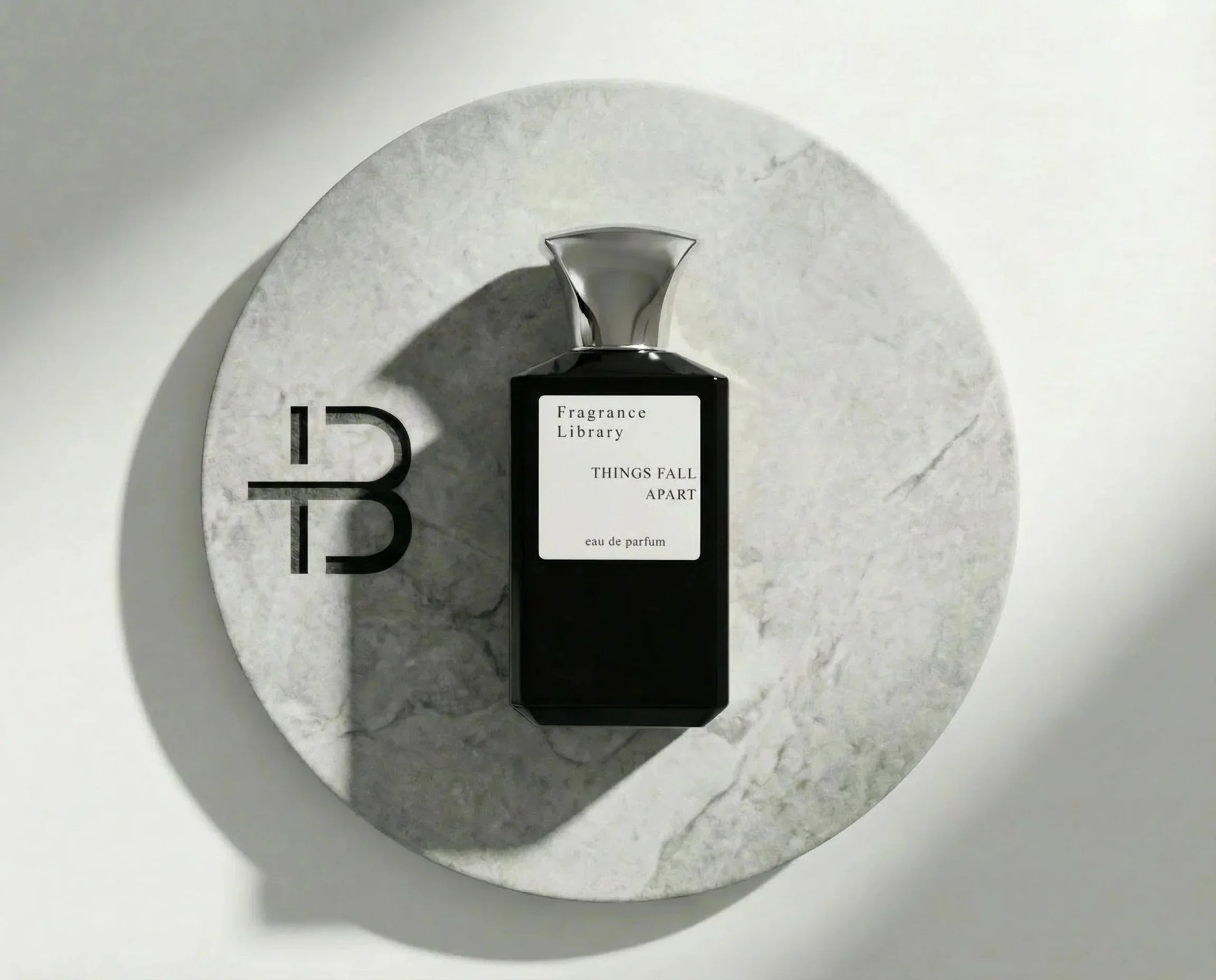 Edles Parfumflakon "Things Fall Apart" auf rundem Marmortablett, luxuriöser Duft