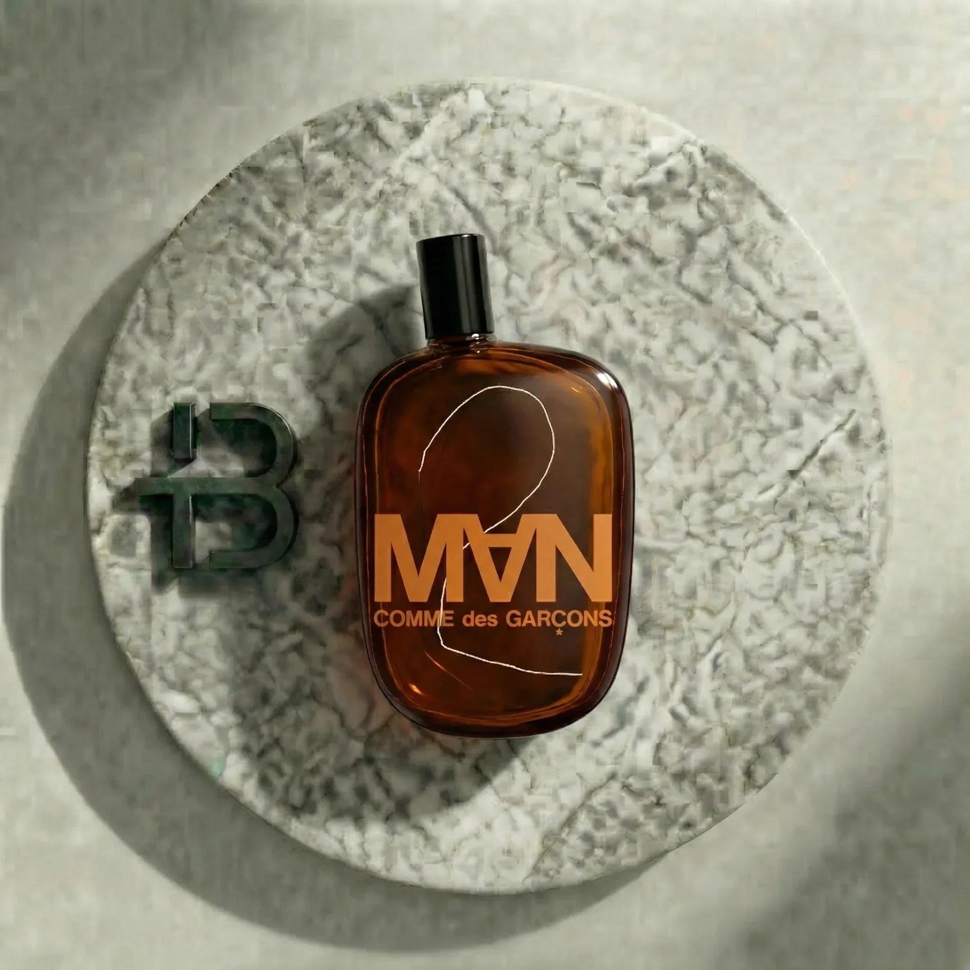 Braune Comme des Garçons MAN Parfumflasche auf Marmorteller, luxuriöses Herrenparfum.