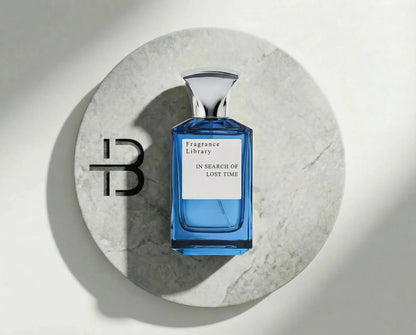 Luxusparfum Flakon in Blau mit silbernem Deckel auf heller Marmorplatte, Etikett sichtbar