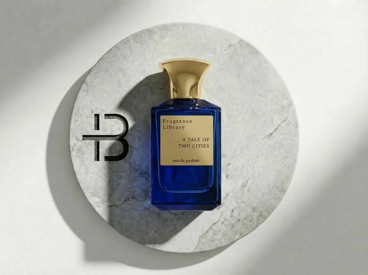 Blauer Parfumflakon von Fragrance Library A Tale Of Two Cities auf weißem Marmorsockel.