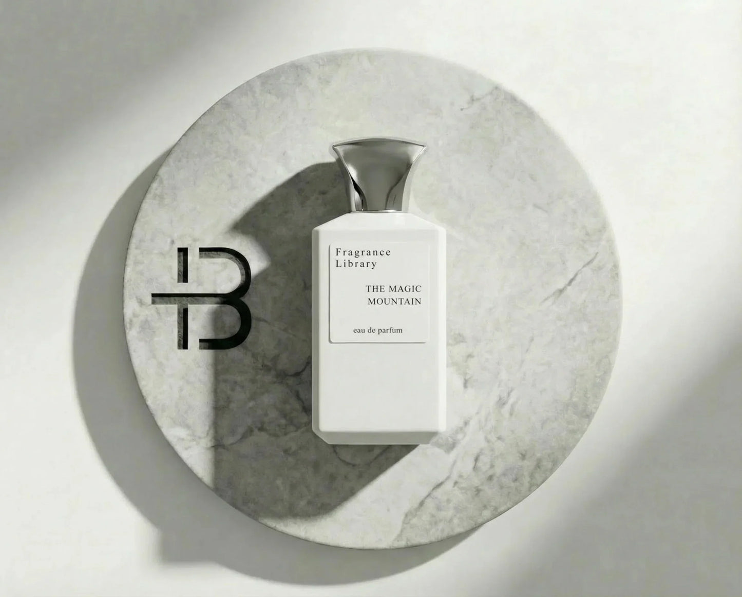 Luxus Parfumflasche auf rundem Marmortablett, Beschriftung The Magic Mountain, elegante Optik