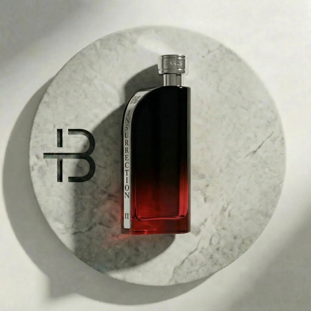 Reyane Tradition Insurrection Dark Parfumflakon mit Farbverlauf auf weißem Marmoruntergrund.