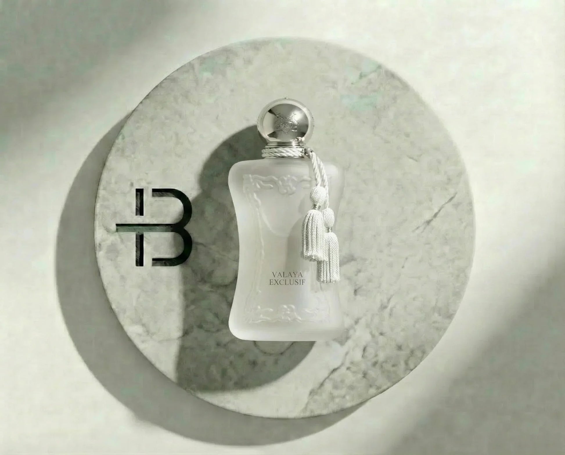 Luxusparfum VALAYA EXCLUSIF in elegantem, mattem Flakon mit silbernem Verschluss auf Marmorplatte
