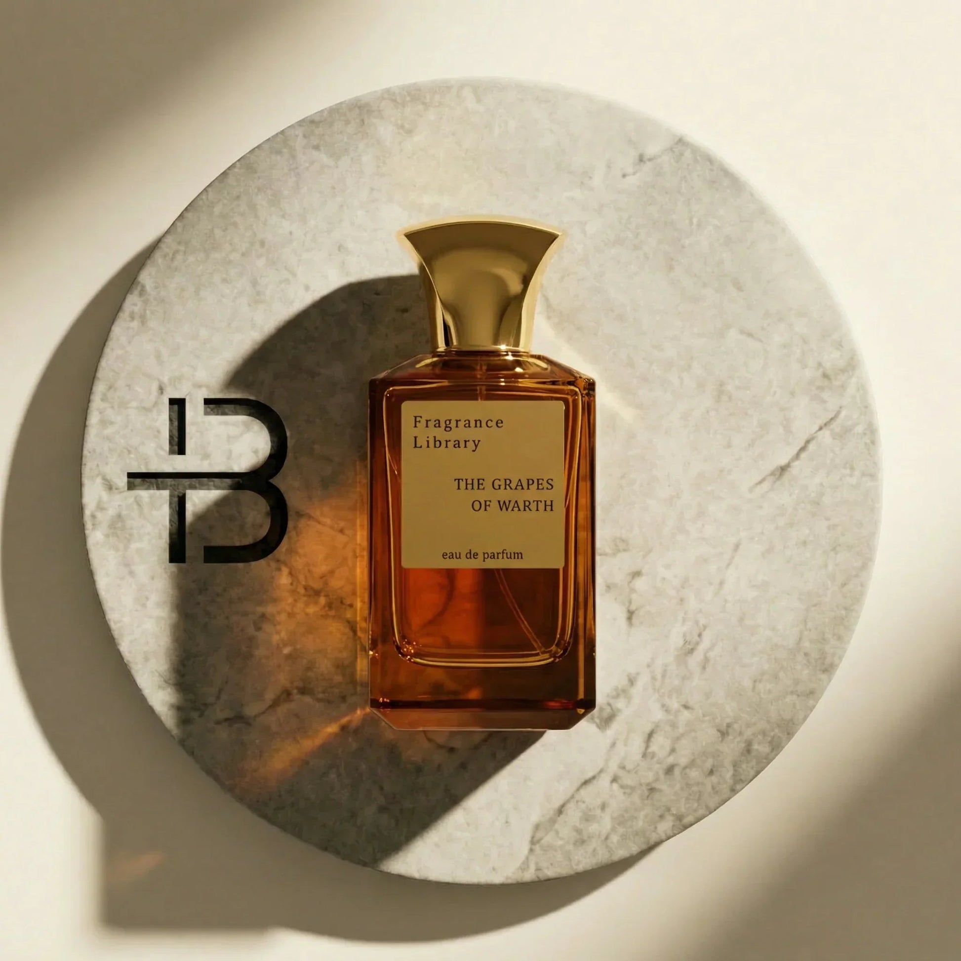 Edles Parfumflakon mit goldenem Verschluss auf rundem Marmor-Untergrund, Luxusduft Präsentation