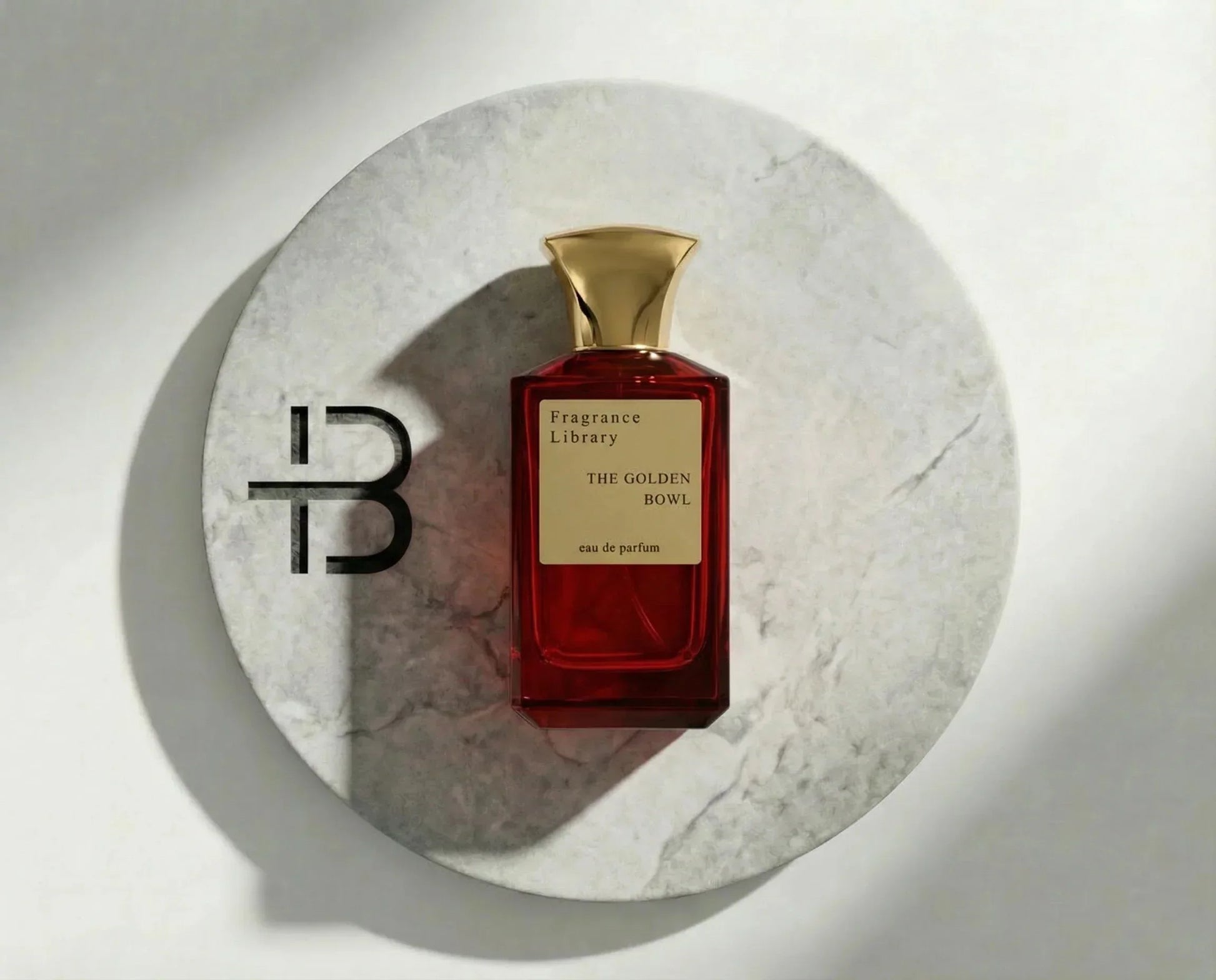 Luxusparfum Flakon in Rot mit goldenem Verschluss auf Marmorplatte, elegantes Duftdesign