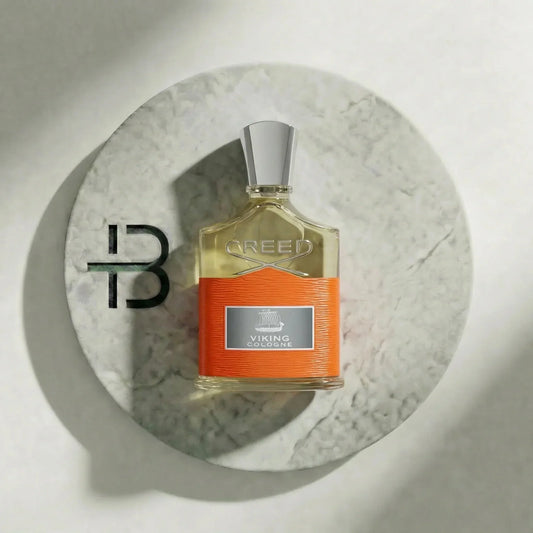 Luxus Herrenparfum Flakon mit silbernem Verschluss und orangem Etikett auf Marmorplatte