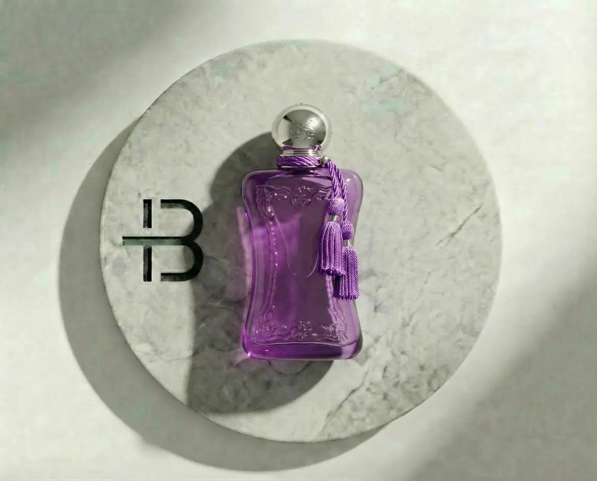 Luxusparfum in eleganter lila Flasche mit silbernem Verschluss auf Marmorplatte