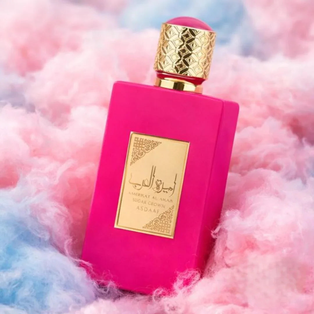 Pinkes Luxusparfum-Flakon mit goldener Verzierung auf pastellfarbenem Hintergrund