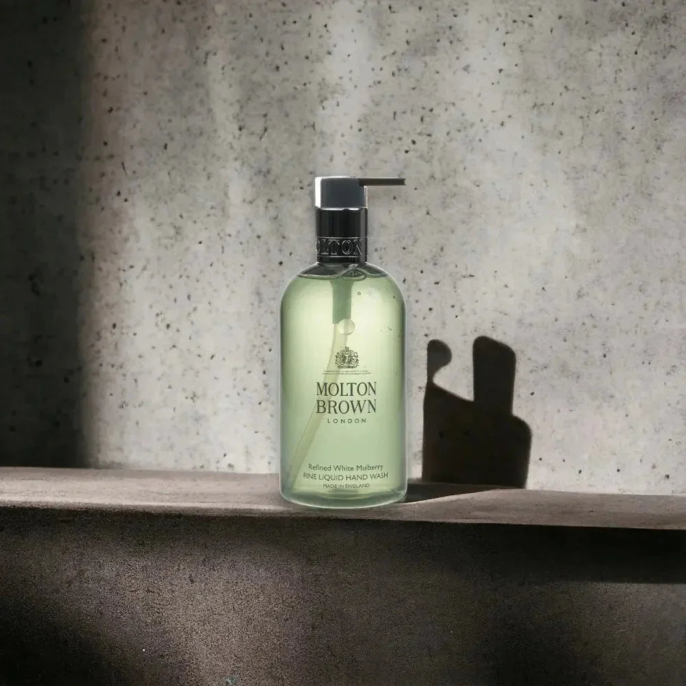 Molton Brown Refined White Mulberry Handseife in transparenter Flasche vor Steinwand