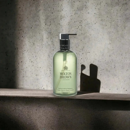 Molton Brown Refined White Mulberry Handseife in transparenter Flasche vor Steinwand