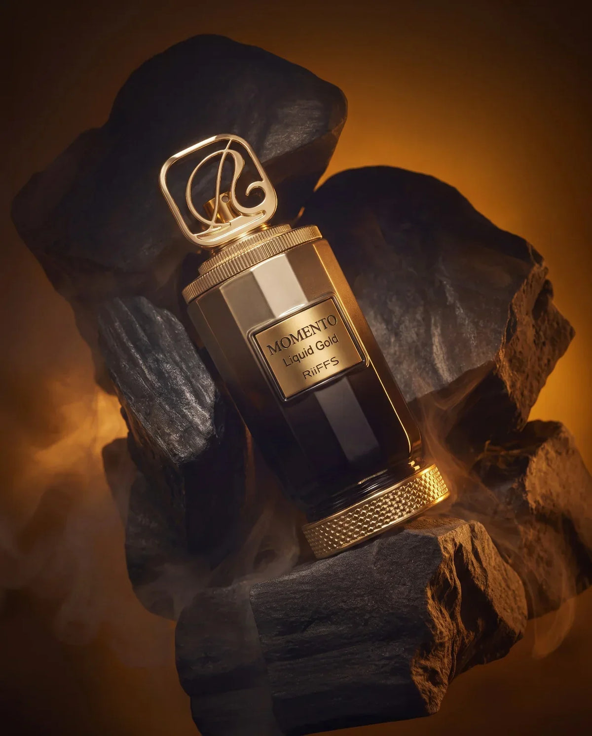 Riiffs Momento Liquid Gold Extrait de Parfum Flakon auf dunklen Steinen mit Goldakzenten.