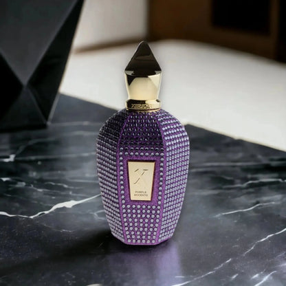 Luxuriöser lila Parfumflakon mit goldener Verzierung auf schwarzem Marmortisch