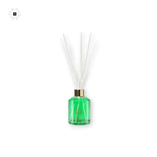 Grüner Raumduft Diffuser mit goldener Kappe und weißen Stäbchen auf weißem Hintergrund